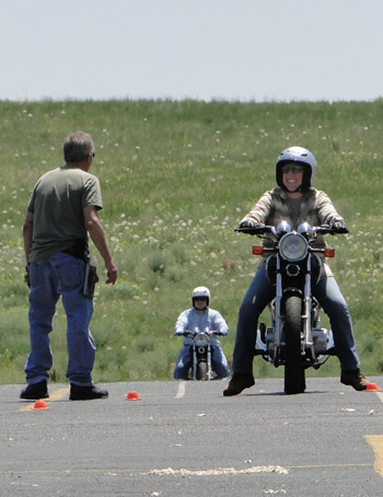 A RiderCoach works with a student on the practice range.