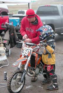 Dad preps son's bike before MX race